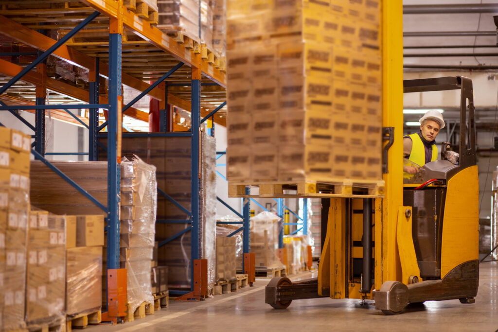 Stock image from Canva of an electric forklift in use to accompany article on warehouse sustainability ideas.