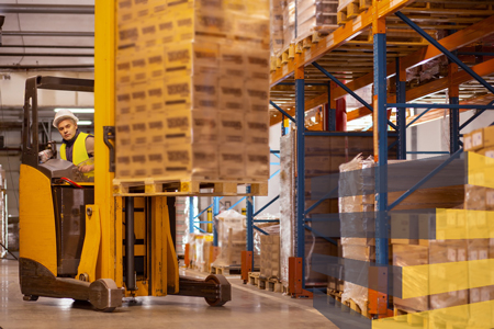 Man using a forklift to illustrate warehouse material handling