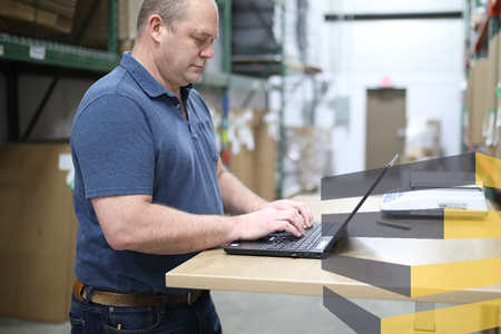 Man using laptop at a warehouse work station