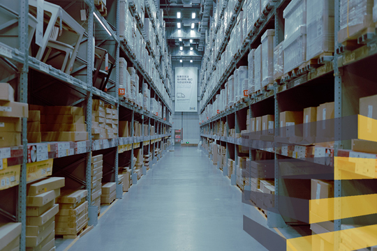 A wide aisle in a warehouse to illustrate article on warehouse aisle signage. By Lance Chang on Unsplash.